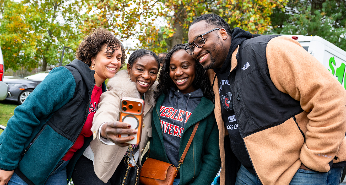 Four alumni posing for a photo during homecoming 2026.