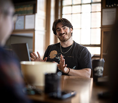 A smiling student in casual clothes talks animatedly inside the Van Vleck Observatory